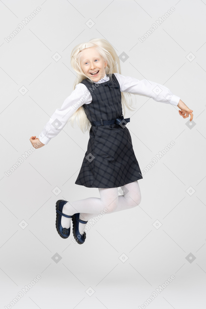 Schoolgirl smiling and jumping up