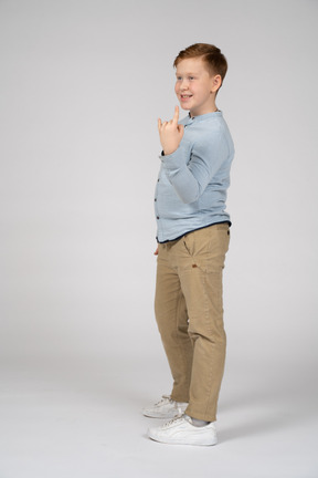 Side view of a boy making rock gesture