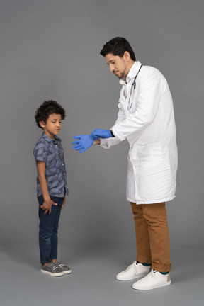 의사의 손을 보고 있는 소년