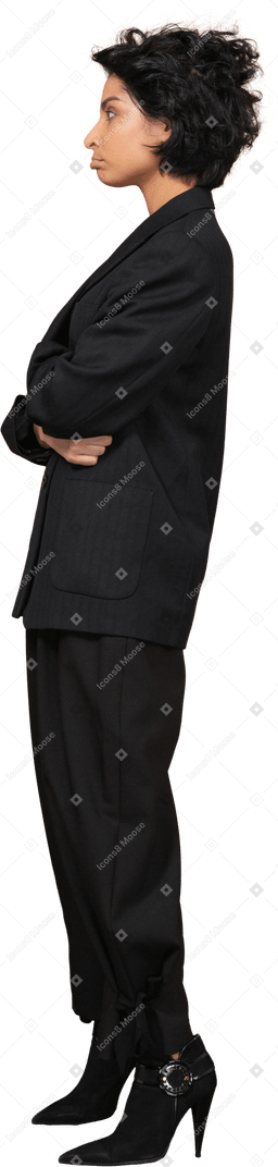 Vista lateral de una empresaria haciendo pucheros vestida con traje negro