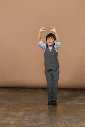 Front view of a boy in grey suit dancing