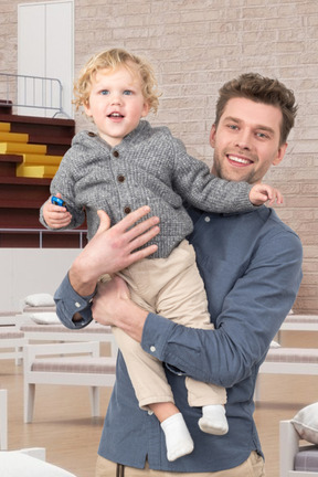 A man holding a little boy in his arms