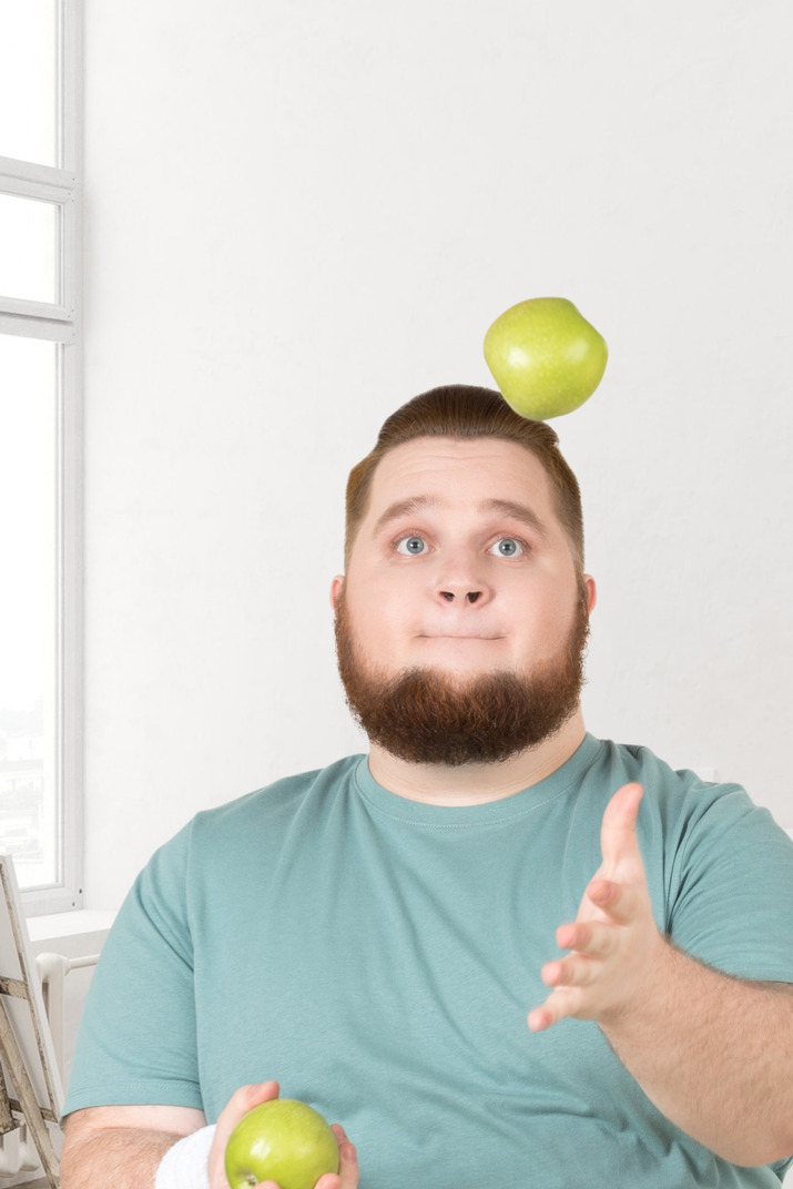 A man sitting in front of an apple