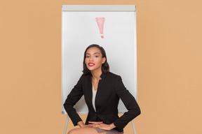 Jolie femme afro assis devant le tableau blanc