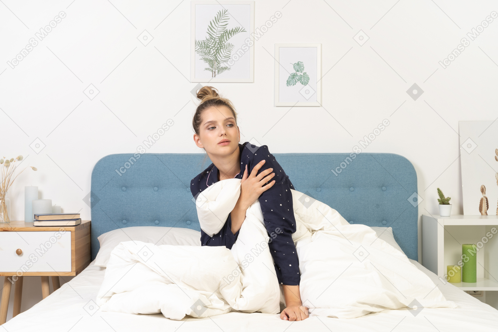 Front view of a tired young woman in pajamas touching her arm while staying in bed