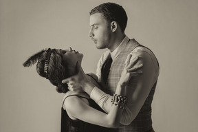Brutal young man holding neck of a beautiful flapper