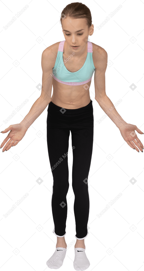 Front view of a teen girl in sportswear outspreading hands and looking down