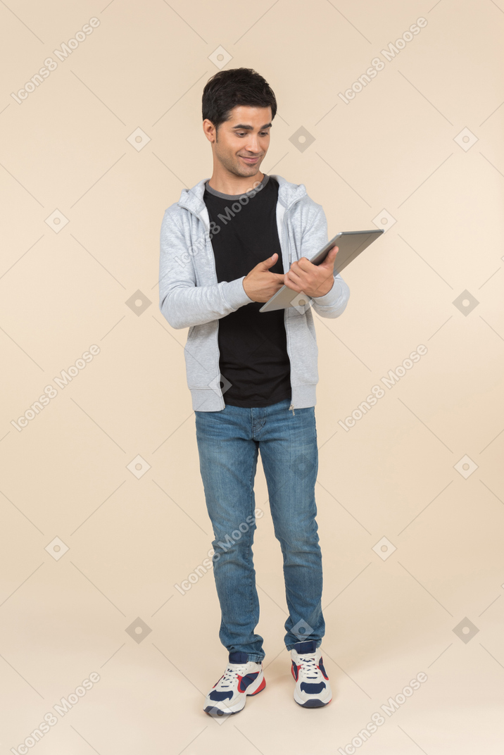 Young caucasian man looking at a digital tablet he's holding