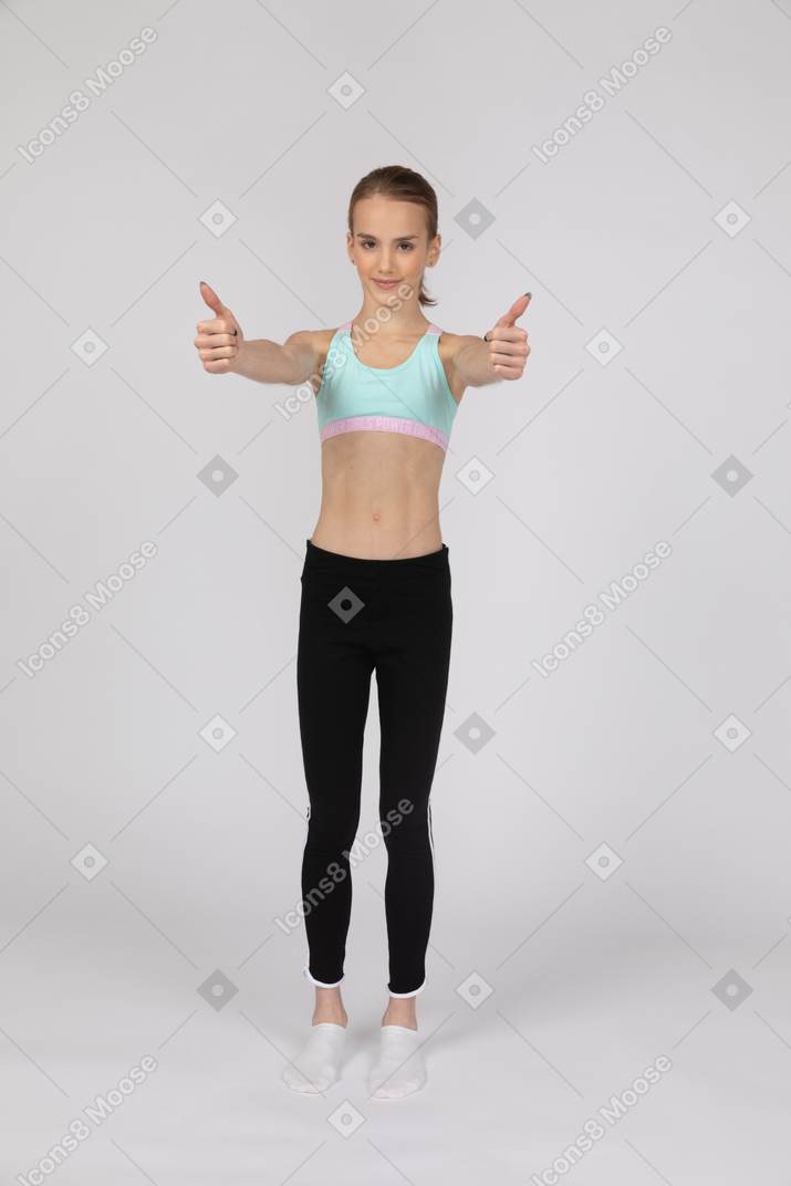 Front view of a teen girl in sportswear putting thumbs up