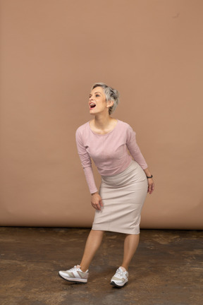 Vista frontal de una mujer feliz en ropa casual de pie con la boca abierta