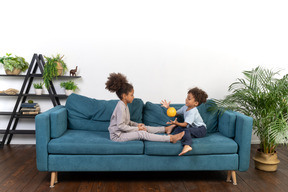 Good looking boy and girl play on the sofa