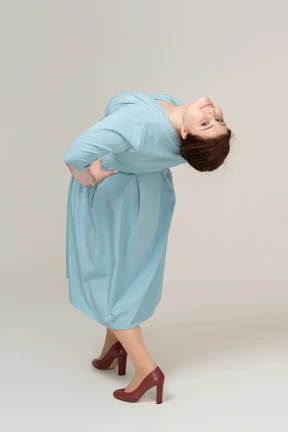 Rear view of a woman in blue dress looking at camera