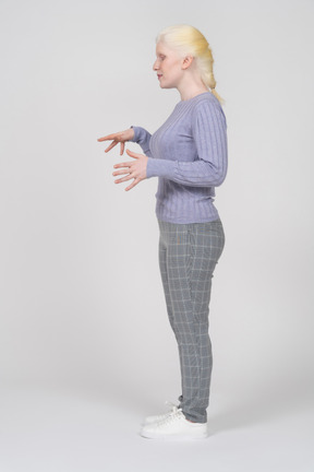 Side view of young woman gesturing and explaining