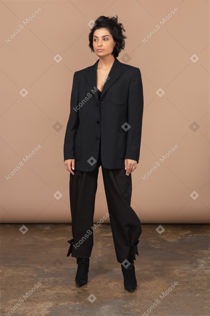 一个不悦的女商人，穿着黑色西装看放在一边的前视图