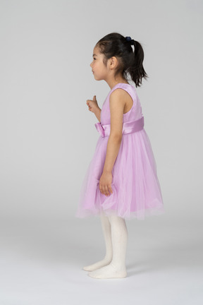 Side view of a little girl pointing to the side