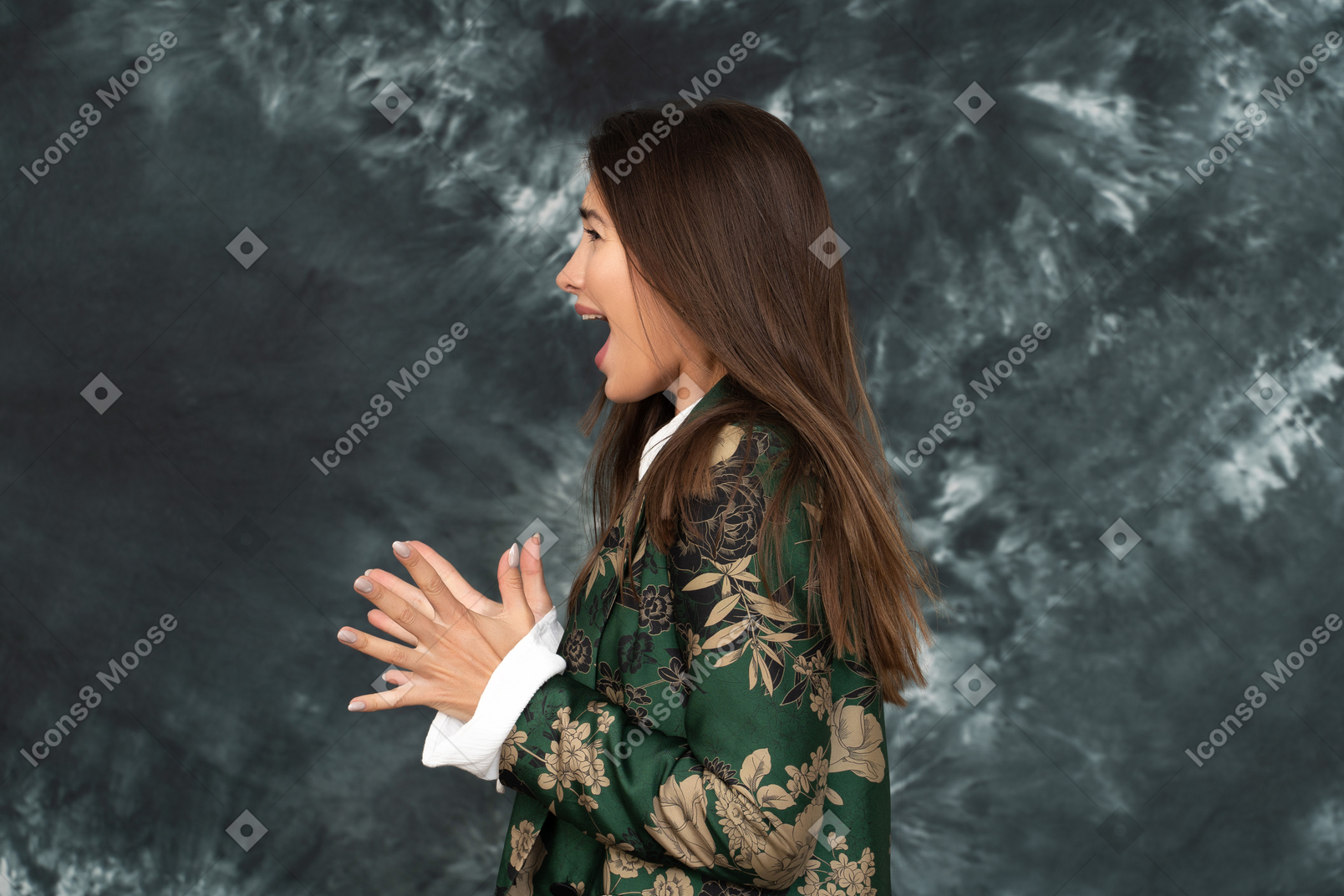 Side portrait of screaming young woman in silk green jacket