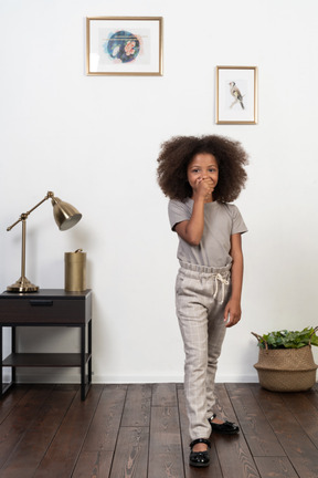 Good looking girl kid posing on the apartment background