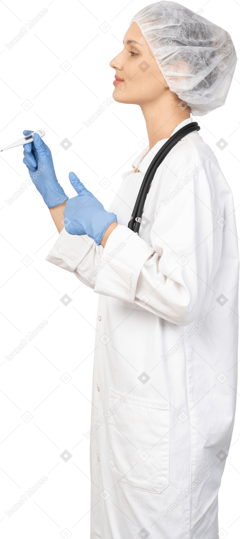 Vue latérale d'une jeune femme médecin avec stéthoscope tenant un thermomètre et montrant le pouce vers le haut