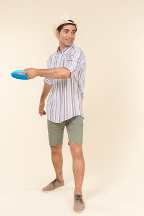 Young caucasian guy throwing frisbee