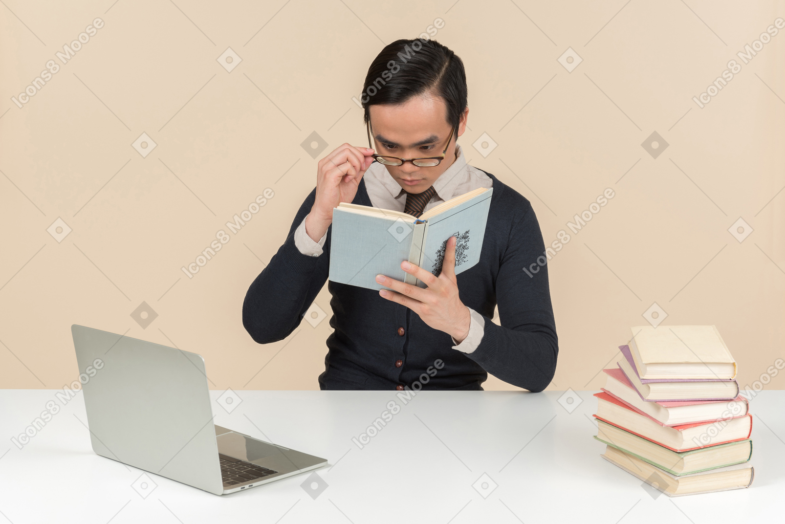 Young asian student in a sweater reading a book