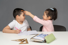 Little girl putting sunglasses on her brother