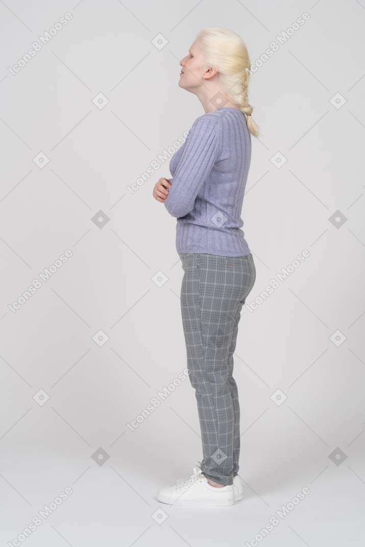 Vista laterale di una donna in piedi con le braccia incrociate