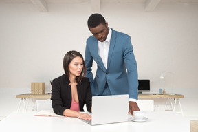 Um homem e uma mulher olhando para um laptop