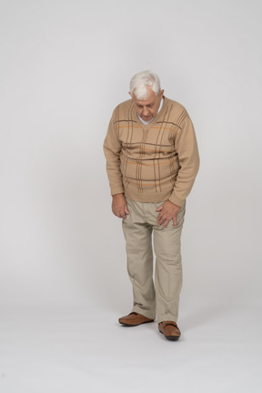 Vue de face d'un vieil homme en vêtements décontractés regardant vers le bas