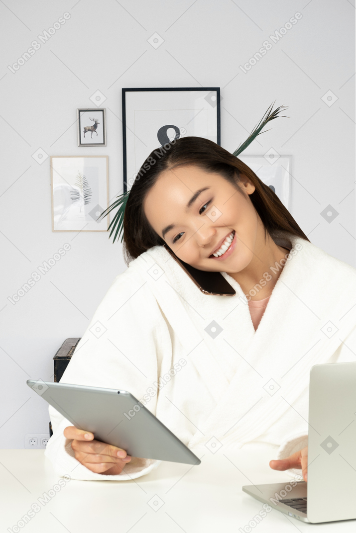 A woman in a bathrobe using a tablet computer