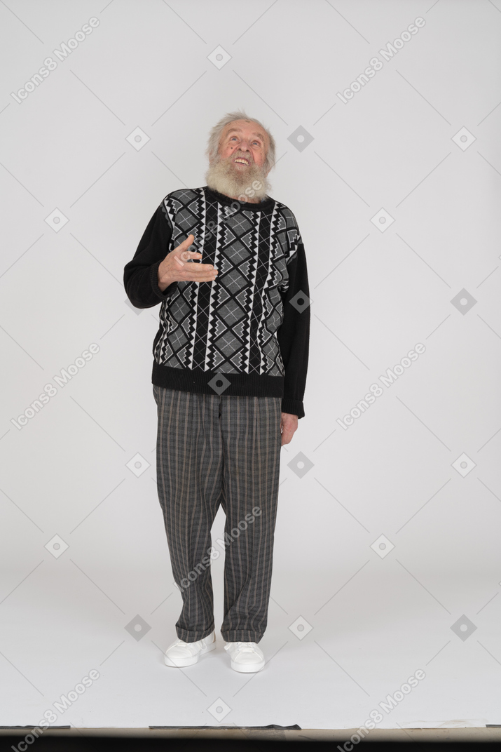 Old man standing and looking up with raised hand