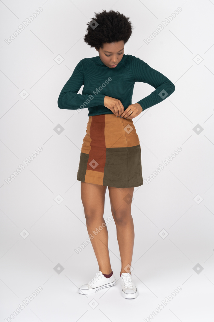 Linda chica africana ajustando su falda