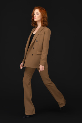 A woman in a brown suit is walking
