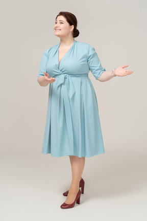 Vista frontale di una donna in abito blu che saluta qualcuno