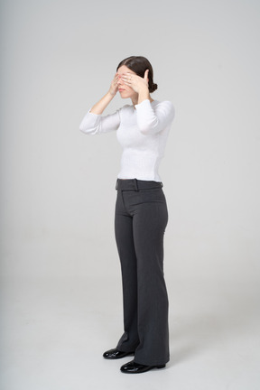 Side view of a woman covering eyes with hands