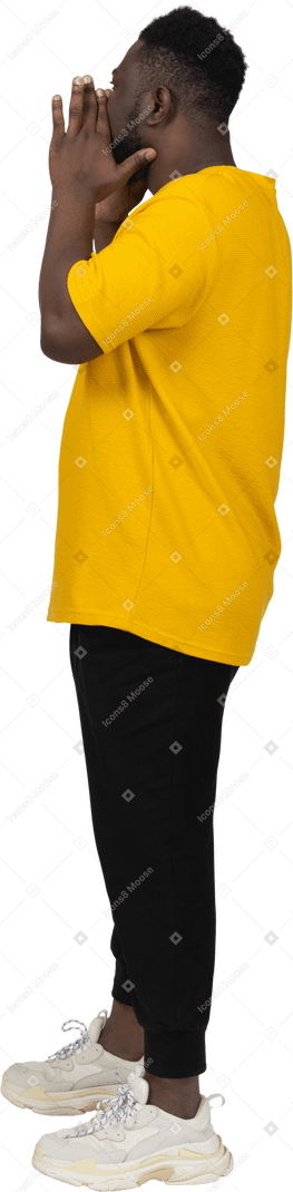一个穿着黄色 t 恤、尖叫的黑皮肤年轻男子的侧视图