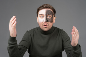 Front view of an astonished male football fan raising hands