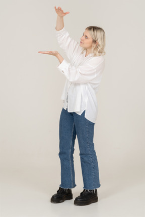 Vue de trois quarts d'une femme blonde montrant une taille de quelque chose