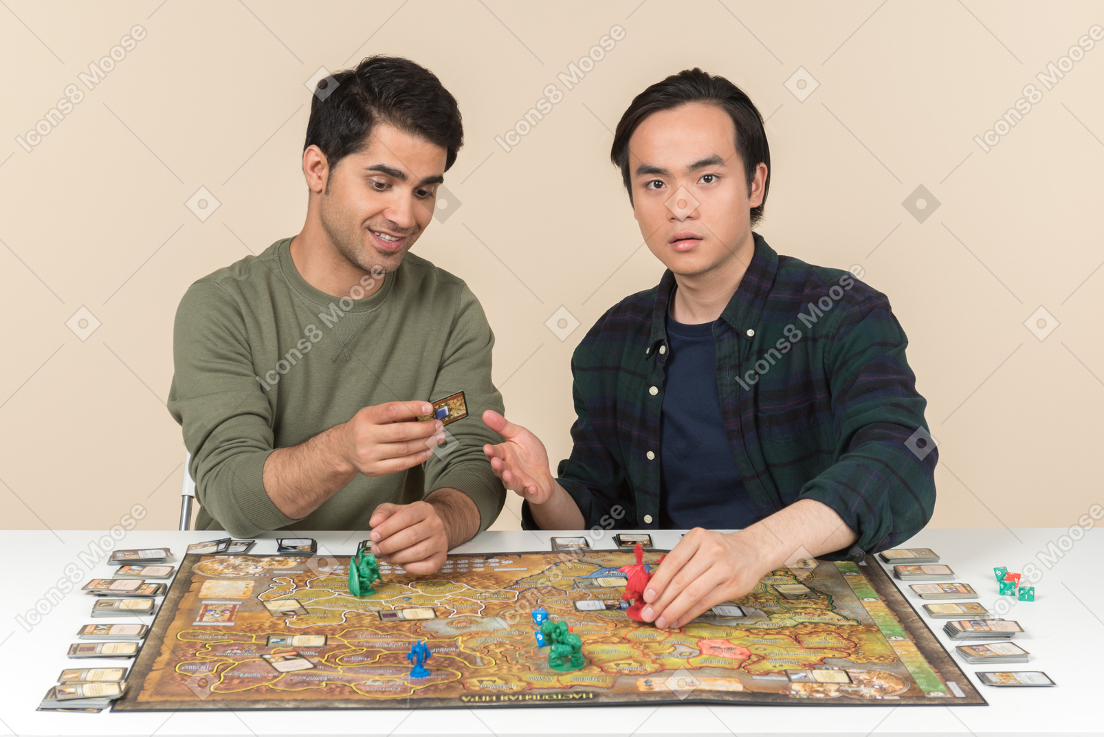 Двое молодых межрасовых друзей сидят за столом и играют в настольную игру