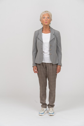 Vista frontale di una vecchia donna in giacca e cravatta che fa smorfie