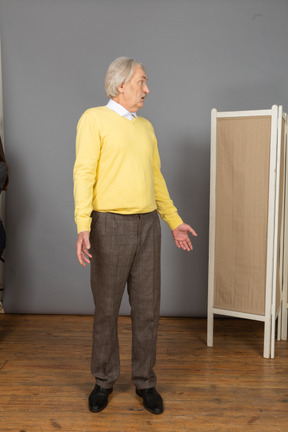 Front view of a questioning old man turning around