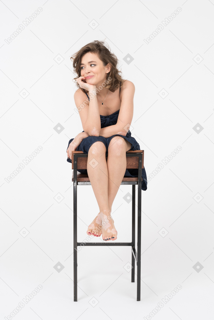 Hermosa mujer joven sentada en una silla de bar