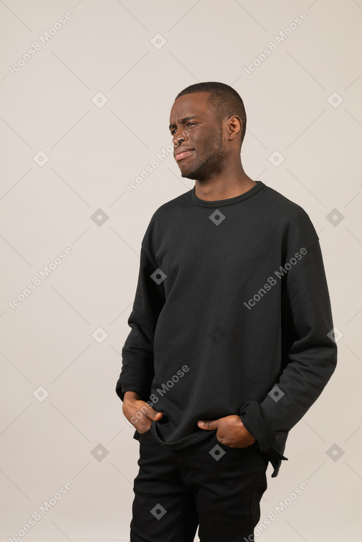 Young man in black clothes looking confused