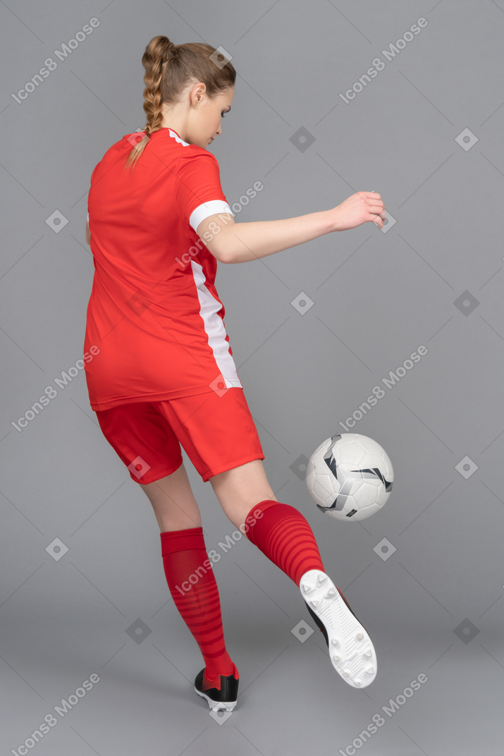 Uma jogadora esportiva está prestes a chutar a bola