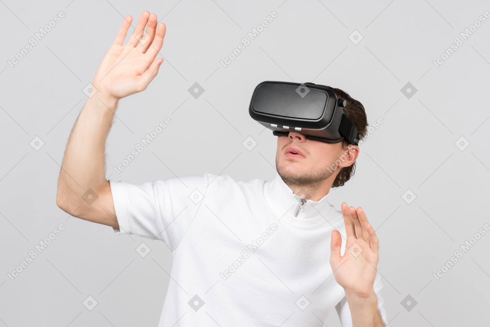 Hombre con casco de realidad virtual de pie con las manos levantadas en señal de rendición.