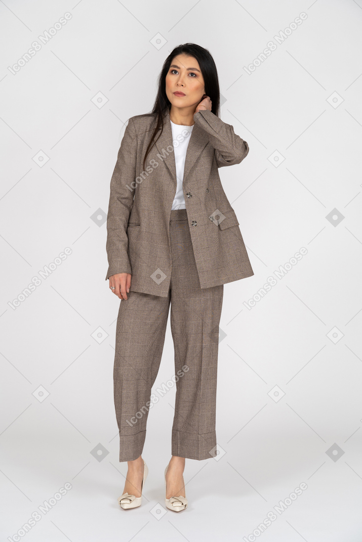 脇を見て茶色のビジネススーツを着た真面目な若い女性の正面図