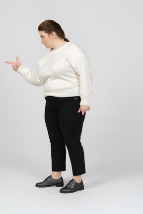 Side view of a plump woman pointing with a finger