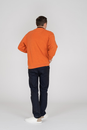 Joven en sudadera naranja de pie