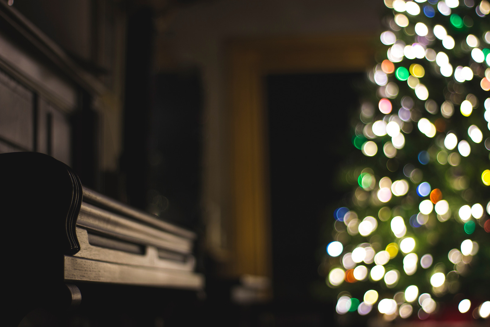ピアノとクリスマス ツリーのある暗い部屋