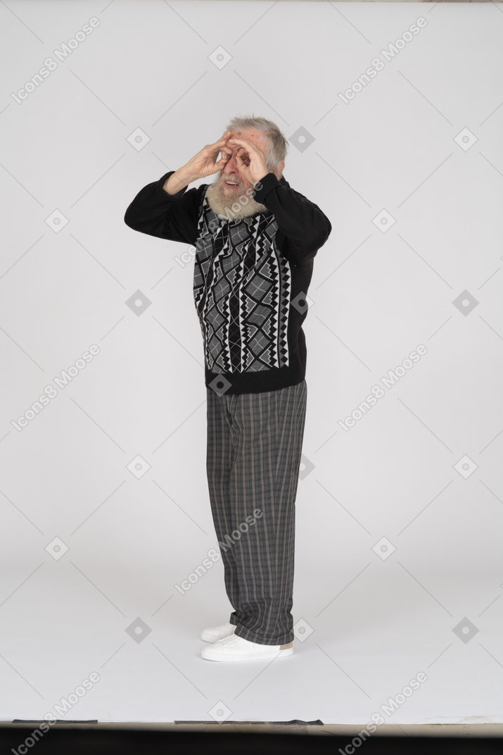 Old man looking into hand binocular