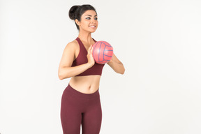 Jeune femme indienne en sporstwear va lancer une balle